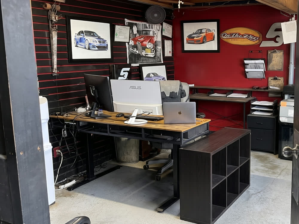The front office, framed car art and the desk where you talk it through